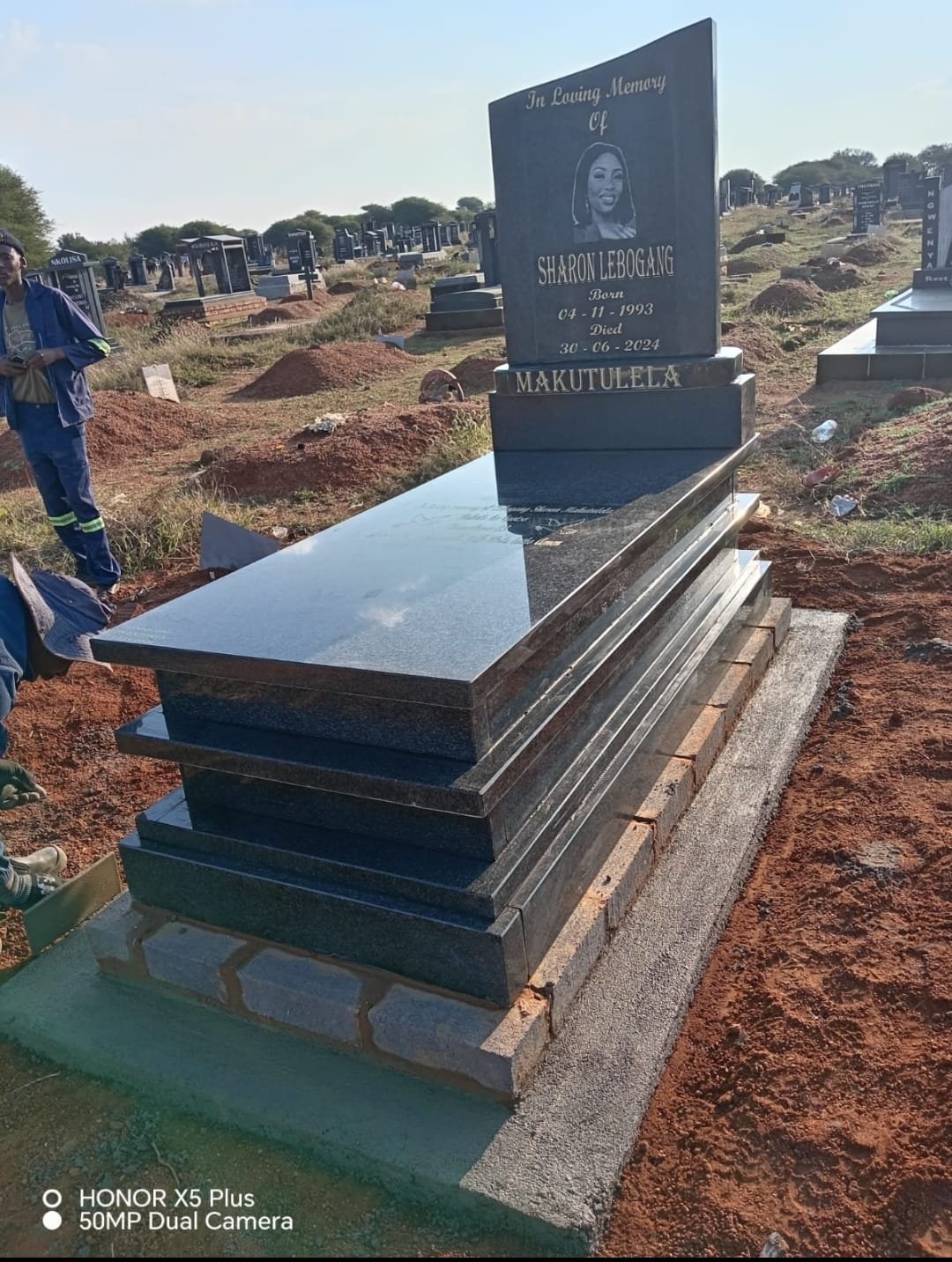 Polished black granite single tombstone with white engraving