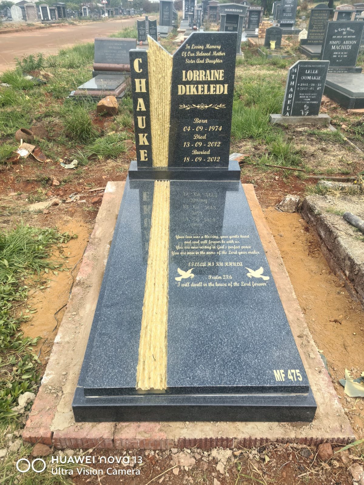Single tombstone with book design and gold lettering
