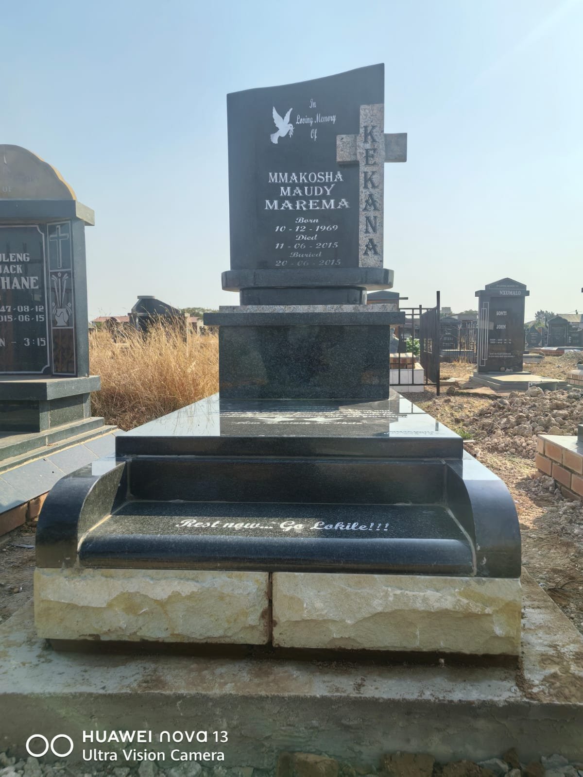 Single black granite memorial with cross and bench design