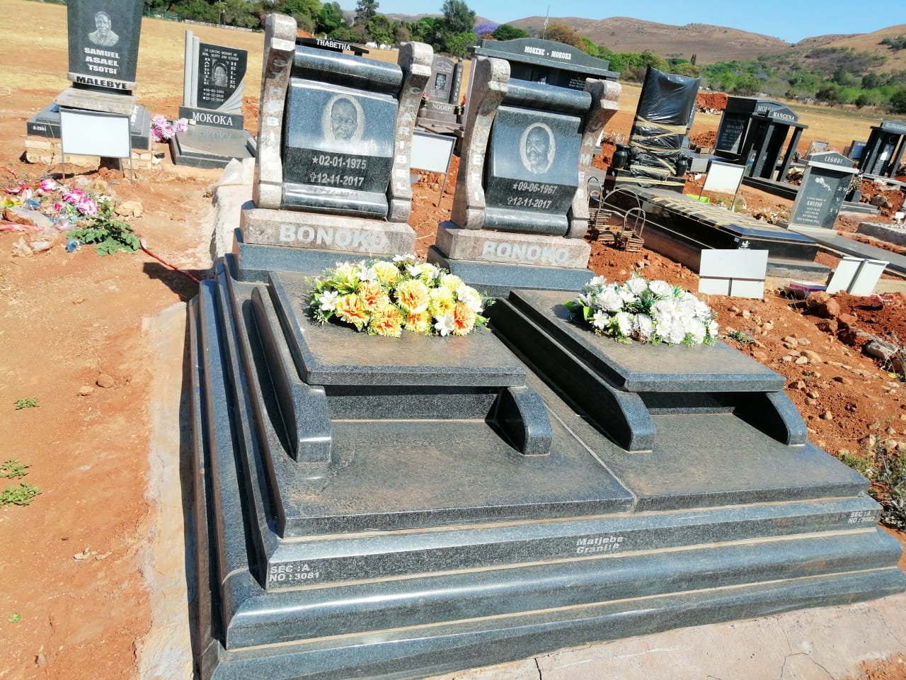 Bonoko double granite memorial with flowers and stepped base
