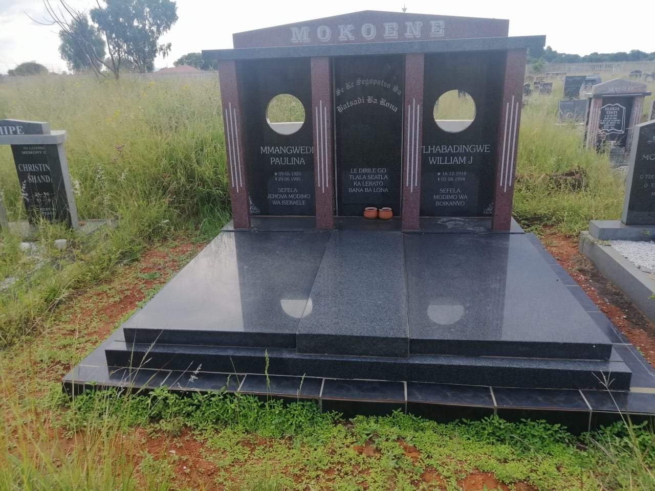 Mokoene double memorial with maroon accents and circular cutouts